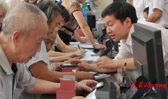 南昌市東湖區(qū)和市民政局工作人員向居家老人介紹專用手機如何使用。